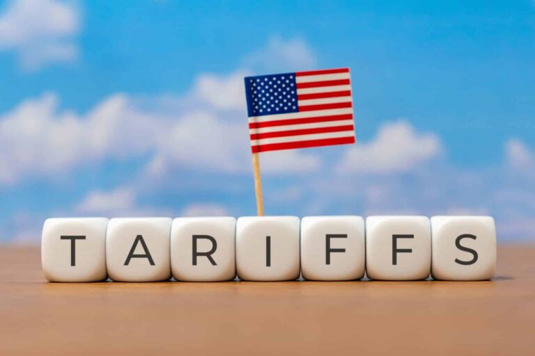 section-301-forced-labor-tariffs | Alliance Drawback Services White letter blocks spell TARIFFS with a small American flag planted among them against a blue sky.